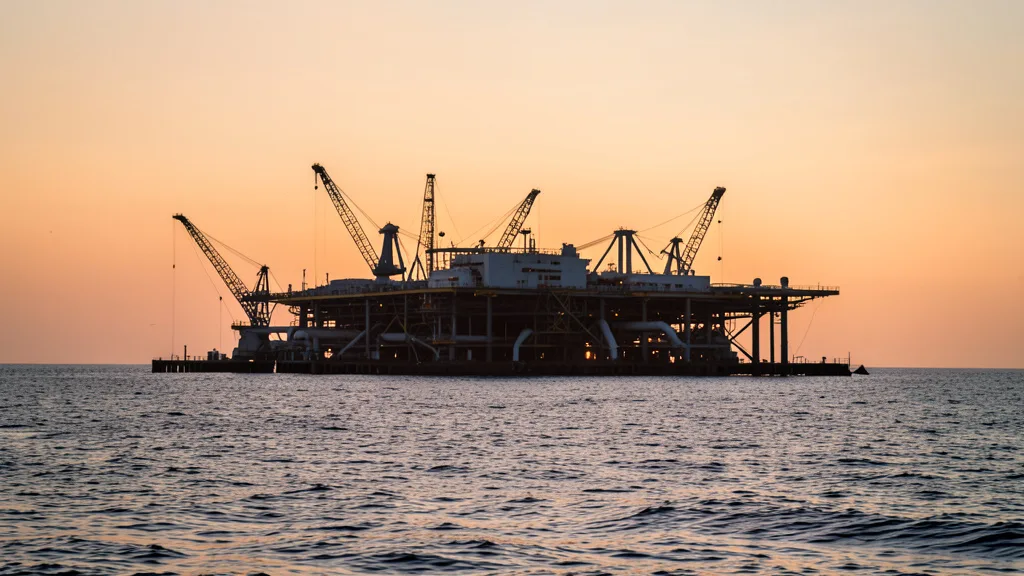 Imagem gerada por IA: Plataforma de petróleo em alto-mar ao amanhecer.