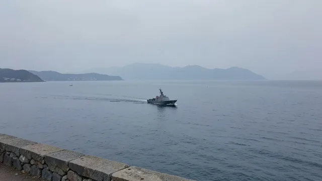 Navio de patrulha navega no estreito de Taiwan sob céu nublado.
