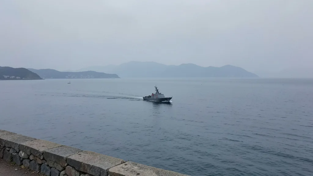 Navio de patrulha navega no estreito de Taiwan sob céu nublado.