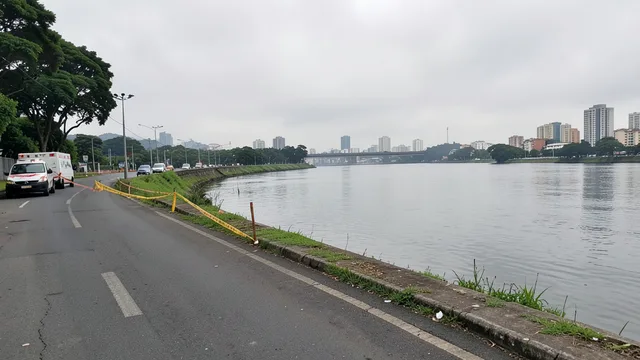 Imagem gerada por IA: Margem do rio Tietê na região da Vila Leopoldina, com veículos de emergência ao fundo.