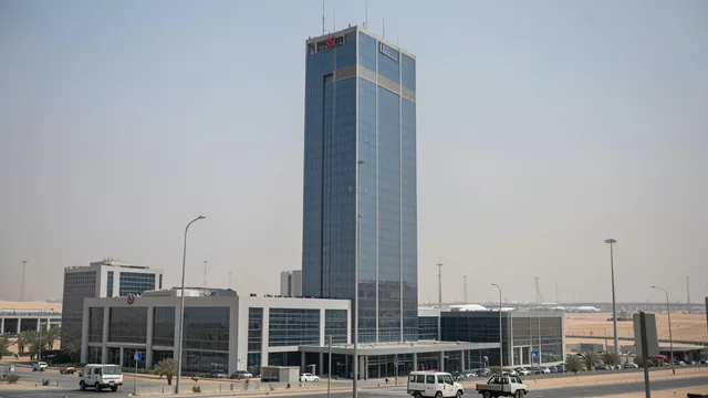 Imagem gerada por IA: Edifício corporativo moderno em Riad, com infraestrutura urbana ao fundo.