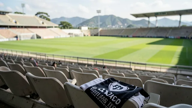 Imagem gerada por IA: Arquibancada vazia de estádio, com um cachecol preto e branco sobre uma cadeira.