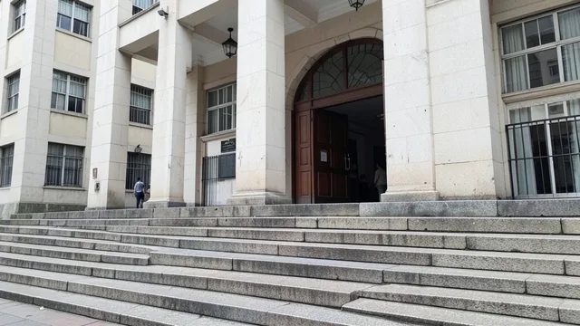 Fachada de um prédio da Justiça em São Paulo, com pessoas caminhando ao fundo.