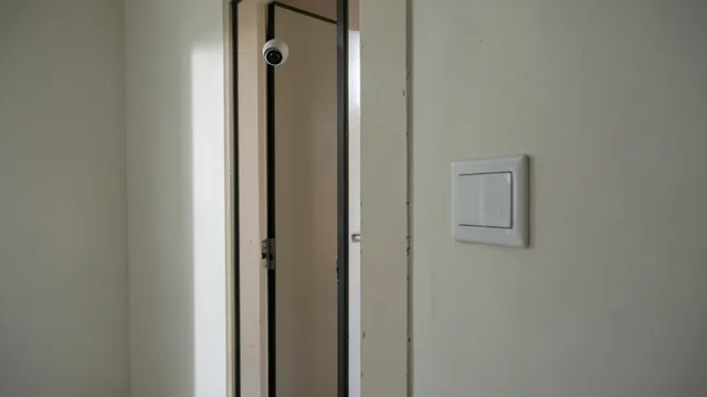 Imagem gerada por IA: Câmera instalada perto da entrada de um banheiro escolar, vista do corredor.