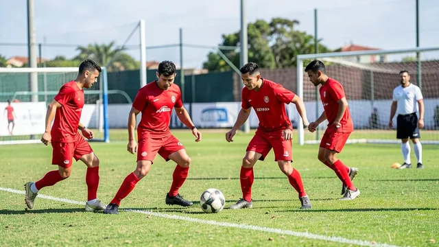 Imagem gerada por IA: Jogadores treinam em um campo de futebol com uniformes vermelhos.