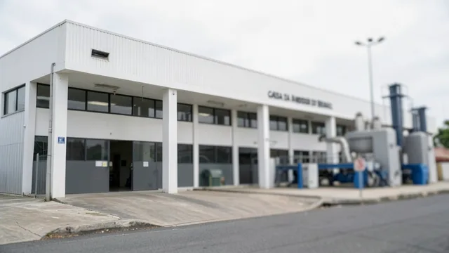 Imagem gerada por IA: Instalações industriais da Casa da Moeda do Brasil, com equipamentos de produção ao fundo.