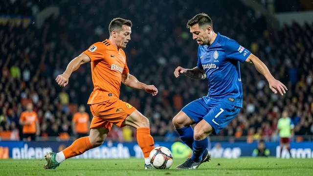 Jogadores de laranja e azul disputam a bola em uma partida internacional de futebol.